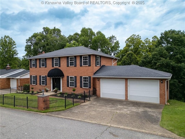81 Hamill Rd, Huntington, WV 25701 - colonial house with a fenced front yard, driveway, an attached garage, and brick siding