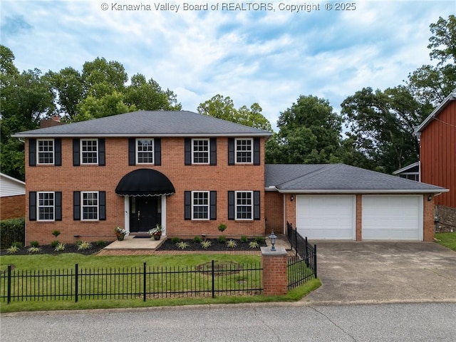 81 Hamill Rd, Huntington, WV 25701 - colonial house featuring a fenced front yard, concrete driveway, and brick siding