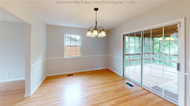81 Hamill Rd, Huntington, WV 25701 - unfurnished room with light wood-style floors, a chandelier, and a textured ceiling