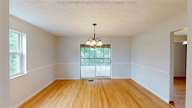 81 Hamill Rd, Huntington, WV 25701 - empty room with light wood-type flooring, a chandelier, and a textured ceiling