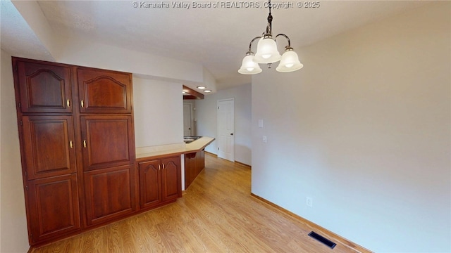81 Hamill Rd, Huntington, WV 25701 - kitchen with light wood-style flooring, a chandelier, light countertops, and hanging light fixtures
