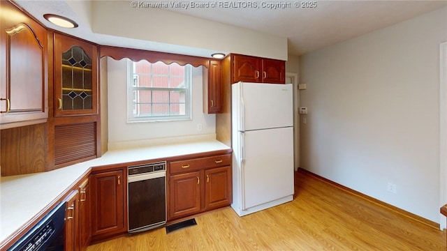 81 Hamill Rd, Huntington, WV 25701 - kitchen with freestanding refrigerator, black dishwasher, light wood-style floors, light countertops, and glass insert cabinets