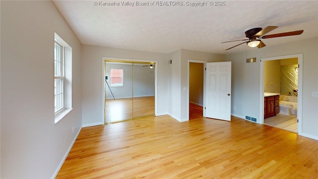 81 Hamill Rd, Huntington, WV 25701 - unfurnished bedroom featuring light wood finished floors, a closet, a textured ceiling, ensuite bath, and a ceiling fan
