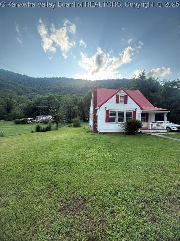 23908 Coal River Rd, Wv, WV 25148 - view of front facade featuring a front yard, a metal roof, and a wooded view