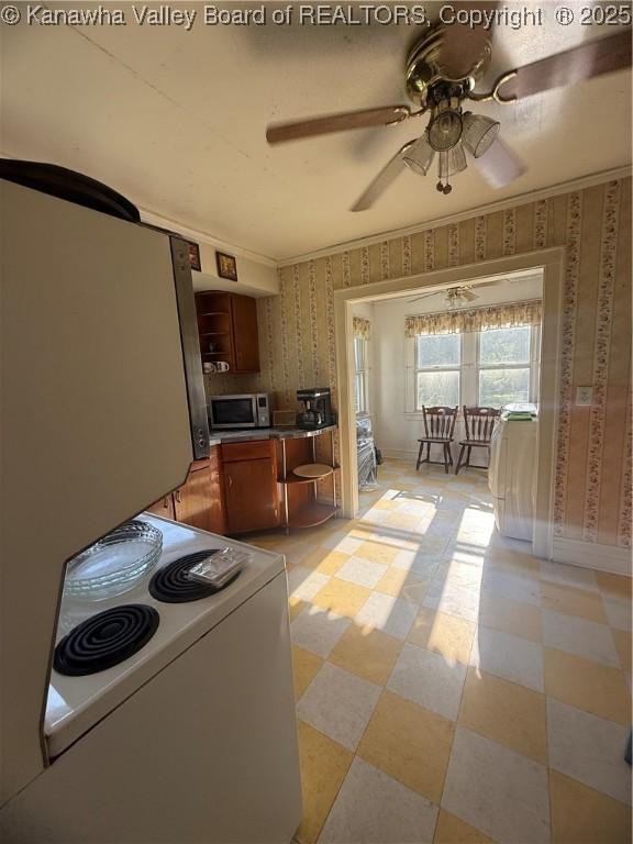 23908 Coal River Rd, Wv, WV 25148 - kitchen with stainless steel microwave, white electric range, wallpapered walls, a ceiling fan, and light flooring