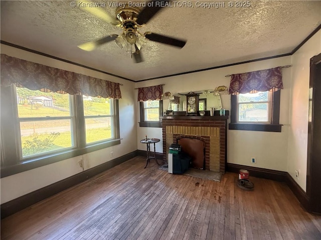 23908 Coal River Rd, Wv, WV 25148 - living area featuring wood-type flooring, a brick fireplace, a textured ceiling, healthy amount of natural light, and ornamental molding