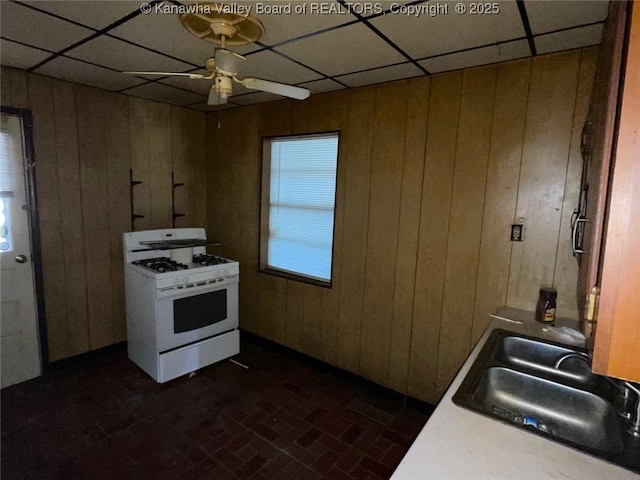 1325 Stuart St, Charleston, WV 25302 - kitchen featuring gas range gas stove, brick patterned floors, a paneled ceiling, wood walls, and ceiling fan