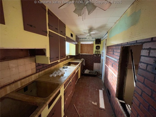 1325 Stuart St, Charleston, WV 25302 - kitchen with a ceiling fan, brick patterned flooring, black electric cooktop, under cabinet range hood, and stovetop