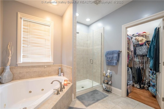 365 Tyler Way, Scott Depot, WV 25560 - bathroom featuring a tub with jets, a stall shower, a walk in closet, and tile patterned flooring