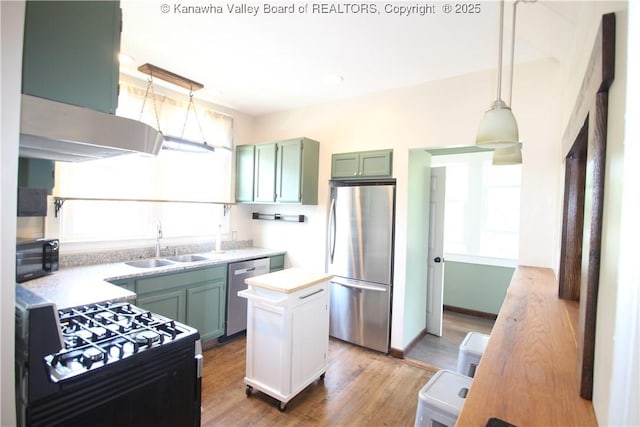 624 Randolph St, Charleston, WV 25302 - kitchen with black appliances, light countertops, wood finished floors, hanging light fixtures, and a kitchen island