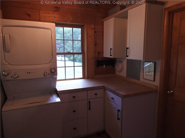 5609 Hurricane Creek Rd, Hurricane, WV 25526 - laundry area with stacked washer and clothes dryer, cabinet space, and wood walls