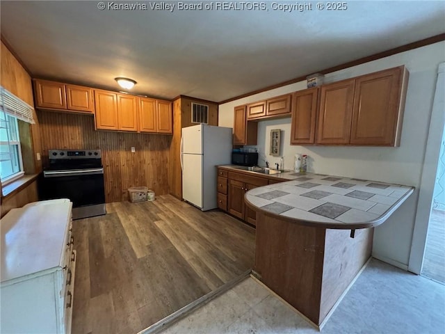 292 Maysel Laurel Ridge Rd, Wv, WV 25133 - kitchen with electric range, freestanding refrigerator, tile counters, a peninsula, and black microwave