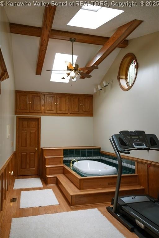 35 Belpac Cir, Logan, WV 25601 - exercise area with a skylight, light wood-style floors, lofted ceiling, a wainscoted wall, and ceiling fan