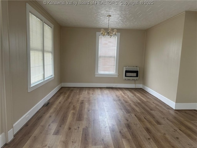 2309 Jefferson Ave, Point Pleasant, WV 25550 - unfurnished dining area featuring heating unit, a chandelier, wood finished floors, and crown molding