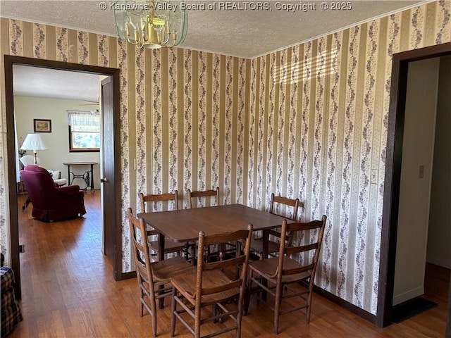 123 2nd St, Burnsville, WV 26335 - dining area featuring wallpapered walls, a textured ceiling, wood finished floors, a chandelier, and ornamental molding
