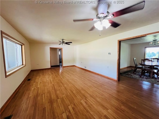 2635 Greenhills Rd, Ravenswood, WV 26164 - unfurnished living room with wood finished floors, a ceiling fan, and a chandelier
