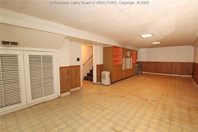 4312 Lancaster Ave, Charleston, WV 25304 - empty room with a wainscoted wall, light floors, wood walls, and stairway