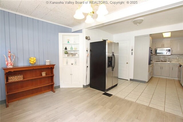 4312 Lancaster Ave, Charleston, WV 25304 - kitchen featuring appliances with stainless steel finishes, a chandelier, light wood-style flooring, decorative backsplash, and light countertops
