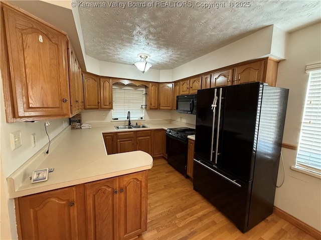 448 18th St, Dunbar, WV 25064 - kitchen featuring black appliances, a textured ceiling, light wood-type flooring, brown cabinetry, and healthy amount of natural light