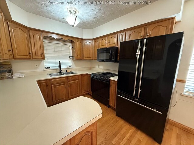 448 18th St, Dunbar, WV 25064 - kitchen featuring black appliances, light wood-style flooring, a textured ceiling, light countertops, and brown cabinetry