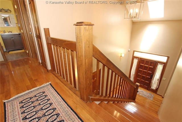119 Falls Run Rd, Charleston, WV 25311 - corridor with an upstairs landing, wood finished floors, and a chandelier