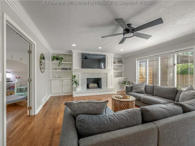 52 Cedar Dr, Hurricane, WV 25526 - living area with a ceiling fan, light wood-style floors, a textured ceiling, crown molding, and a premium fireplace
