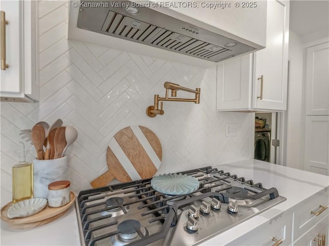 52 Cedar Dr, Hurricane, WV 25526 - kitchen with wall chimney exhaust hood, stainless steel gas stovetop, backsplash, light countertops, and white cabinetry