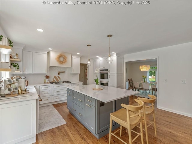 52 Cedar Dr, Hurricane, WV 25526 - kitchen featuring gray cabinets, white cabinetry, multiple ovens, light countertops, and light wood-type flooring