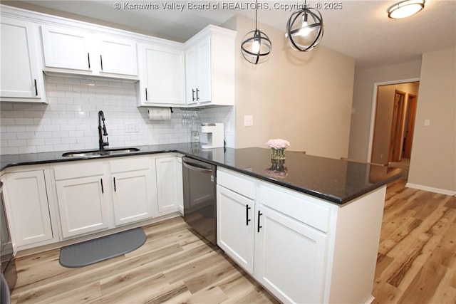 1412 Wilkie Dr, Charleston, WV 25314 - kitchen featuring stainless steel dishwasher, backsplash, light wood-type flooring, white cabinetry, and a peninsula