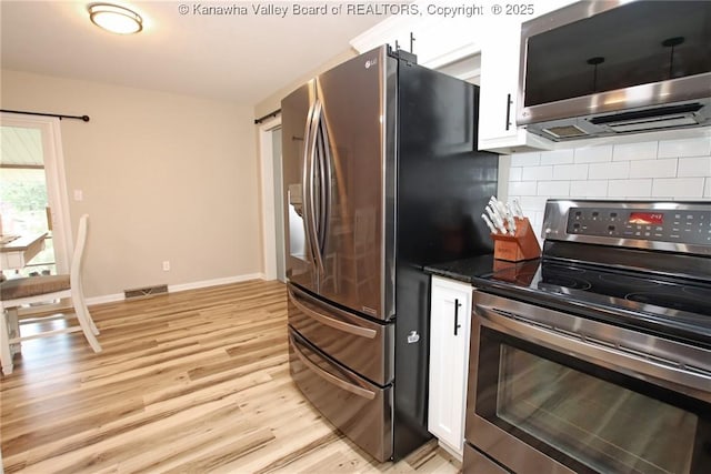 1412 Wilkie Dr, Charleston, WV 25314 - kitchen featuring appliances with stainless steel finishes, decorative backsplash, light wood-style floors, white cabinets, and dark countertops