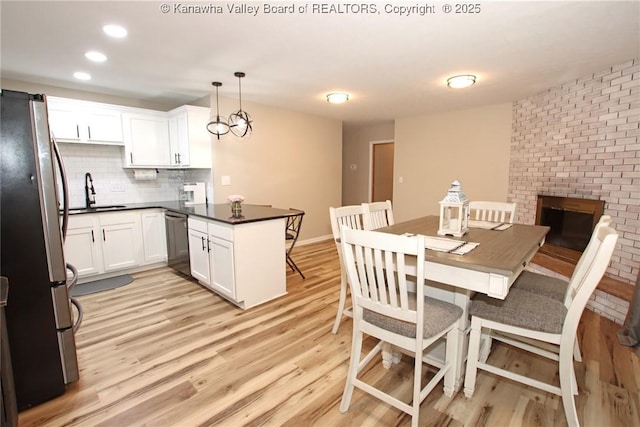 1412 Wilkie Dr, Charleston, WV 25314 - kitchen featuring appliances with stainless steel finishes, a peninsula, light wood-style flooring, dark countertops, and recessed lighting