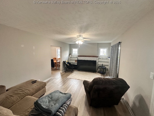 191 N Park Dr, Point Pleasant, WV 25550 - living room with a fireplace, light wood-style flooring, a ceiling fan, and a textured ceiling