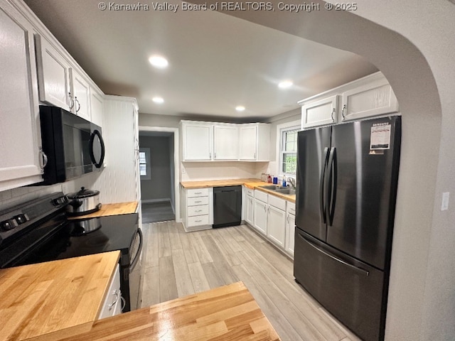 191 N Park Dr, Point Pleasant, WV 25550 - kitchen with black appliances, butcher block counters, light wood finished floors, arched walkways, and white cabinets