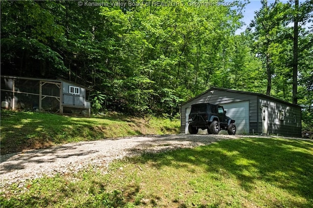 180 Tryphenia Rd, Hurricane, WV 25526 - view of green lawn with an outdoor structure, a garage, and a forest view