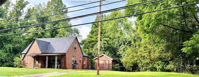 17739 US Route 60, Culloden, WV 25510 - exterior space featuring a storage unit, a front lawn, brick siding, and roof with shingles
