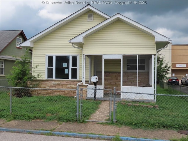 4808 Kentucky St, South Charleston, WV 25309 - view of front of property with a fenced front yard, stone siding, a sunroom, and a gate