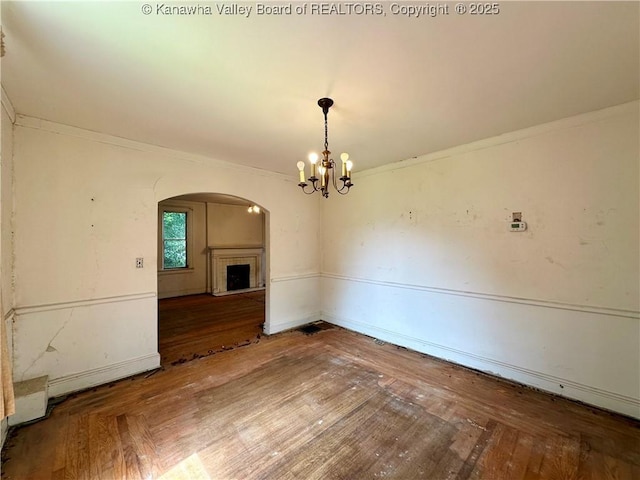 5430 Virginia Ave SE, Charleston, WV 25304 - empty room featuring arched walkways, a chandelier, ornamental molding, wood finished floors, and a fireplace