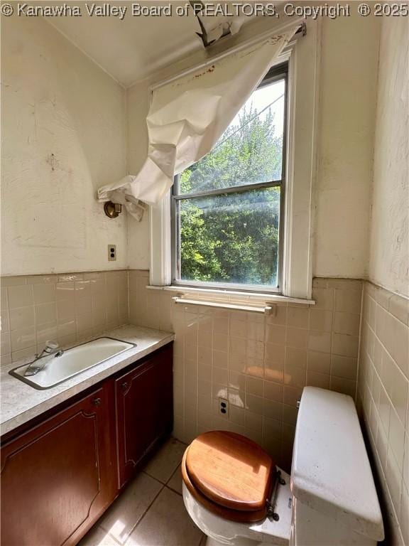 5430 Virginia Ave SE, Charleston, WV 25304 - half bathroom featuring tile walls, a wainscoted wall, vanity, and tile patterned flooring