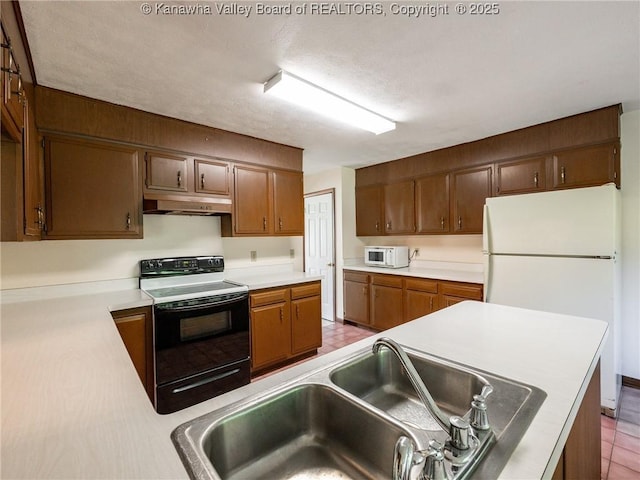 1846 Scott Depot Rd, Scott Depot, WV 25560 - kitchen featuring white appliances, under cabinet range hood, light countertops, and brown cabinetry