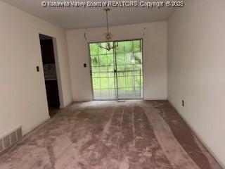 873 Woods Dr, Saint Albans, WV 25177 - unfurnished dining area with a chandelier and carpet floors