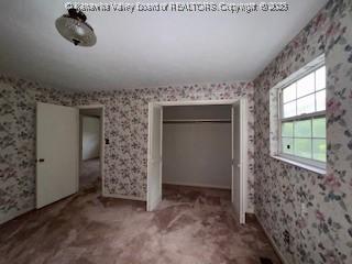 873 Woods Dr, Saint Albans, WV 25177 - unfurnished bedroom featuring a closet, wallpapered walls, and carpet floors