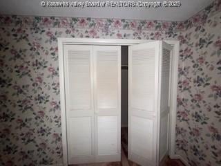 873 Woods Dr, Saint Albans, WV 25177 - unfurnished bedroom featuring wallpapered walls and a closet