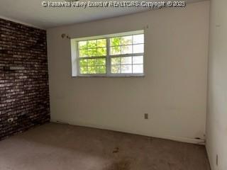 873 Woods Dr, Saint Albans, WV 25177 - spare room featuring carpet and brick wall