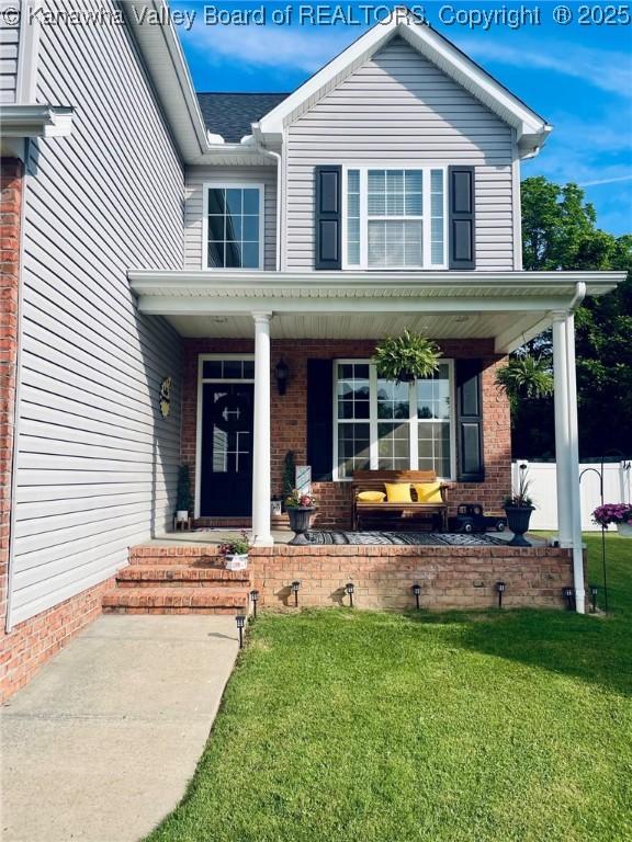 4052 Farmington Dr, Hurricane, WV 25526 - doorway to property with a porch, a lawn, and brick siding