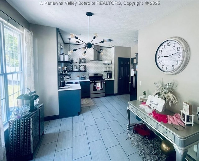 4052 Farmington Dr, Hurricane, WV 25526 - kitchen with stainless steel range, range hood, freestanding refrigerator, a chandelier, and light countertops
