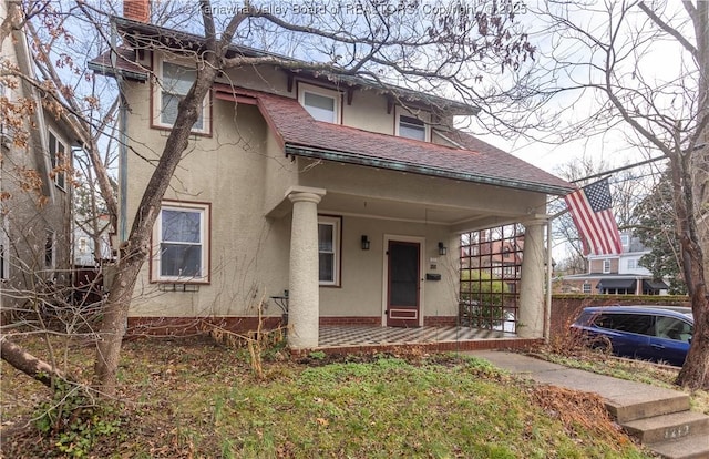 1212 10th St, Huntington, WV 25701 - view of front facade featuring covered porch, stucco siding, a chimney, and roof with shingles