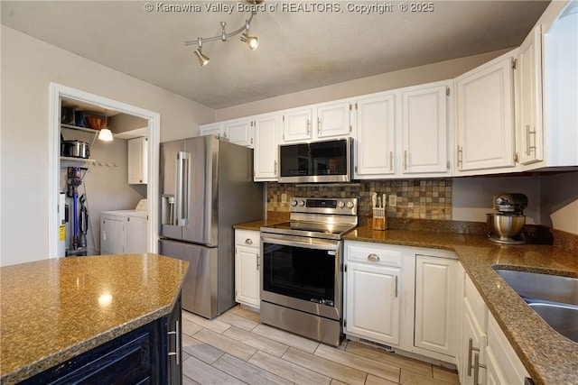 18 Long St, Winfield, WV 25213 - kitchen featuring stainless steel appliances, washing machine and clothes dryer, white cabinets, decorative backsplash, and wood finish floors