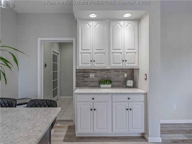 1437 Statts Mills Rd, Ripley, WV 25271 - kitchen featuring white cabinetry, tasteful backsplash, and light wood-style floors