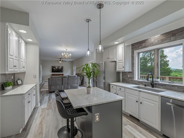 1437 Statts Mills Rd, Ripley, WV 25271 - kitchen featuring appliances with stainless steel finishes, a kitchen island, open floor plan, decorative backsplash, and white cabinetry