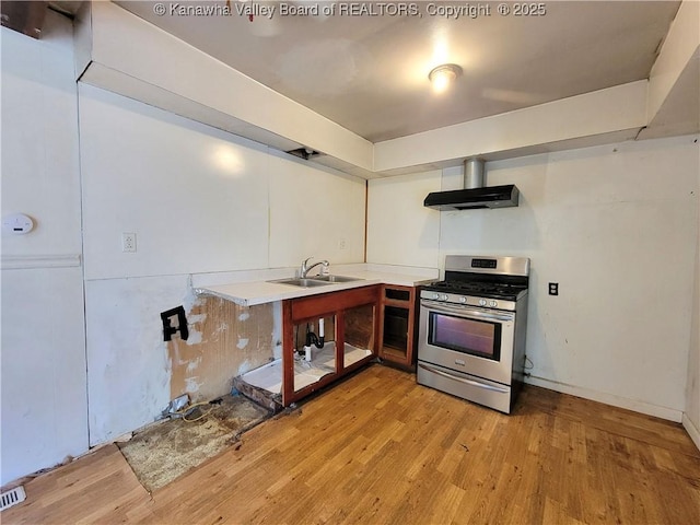 807 Honeysuckle Rd, Elkview, WV 25071 - kitchen with stainless steel gas stove, light wood-type flooring, extractor fan, and wall chimney range hood